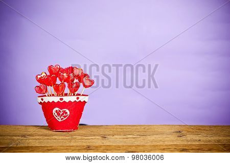 red heart shape lollipops in a red pot