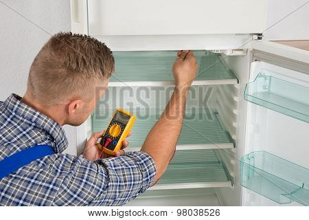 Technician Checking Fridge With Multimeter