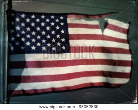 Torn and tattered American Flag blowing in the wind - Independence Day - Instagram style vintage filter applied
