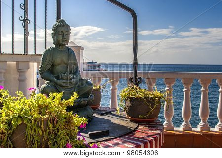 buddha statue sitting a front of sea