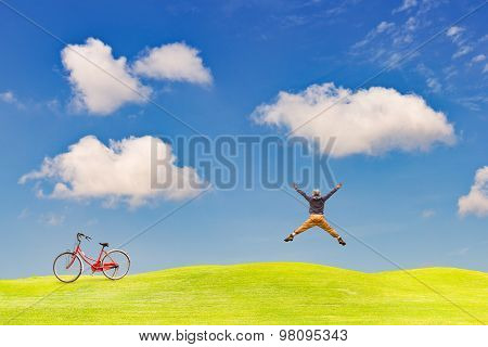 Happy Man Jumping On Green Grass Field