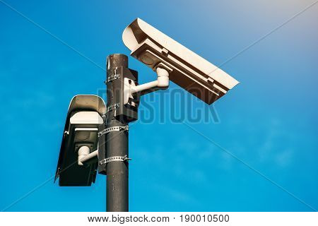 CCTV camera modern era anti-terrorist electronic surveillance security cameras against blue sky that symbolizes freedom