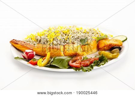 Low angle view of salmon kebab on simple plate on white tabletop. Indoor studio shot. Fusion food concept for meal of sustainably grown marine finfish rich in long chain polyunsaturated fatty acids.