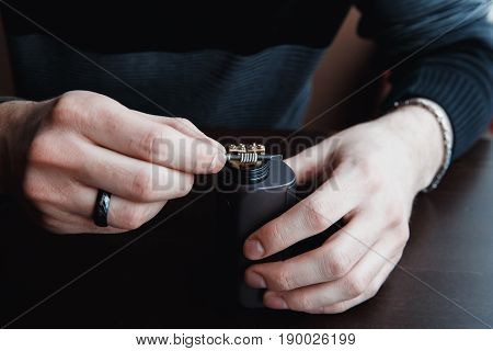male master installs a coyle. Spiral for electronic evaporator and cigarette. Vape, vaping