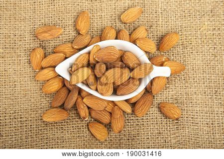Almonds In White Ceramic Bowl On Sack Background