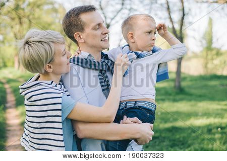 family stands outside togather and looks in one direction