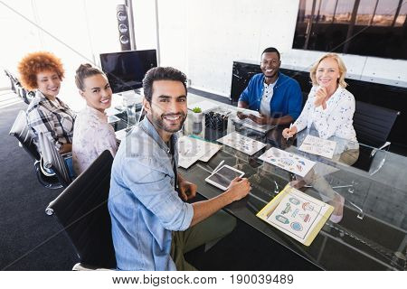High angle portrait of business people sitting at confrence table in creative office