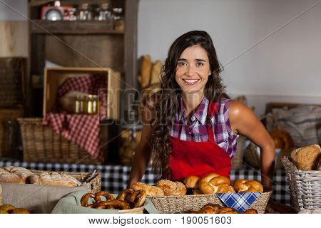 Portrait of female staff standing at bakery section in supermarket