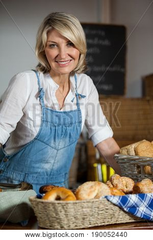 Portrait of female staff standing at bakery section in supermarket