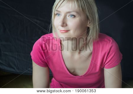 Studio headshot portrait of mature woman wearing fuchsia sleevless shirt