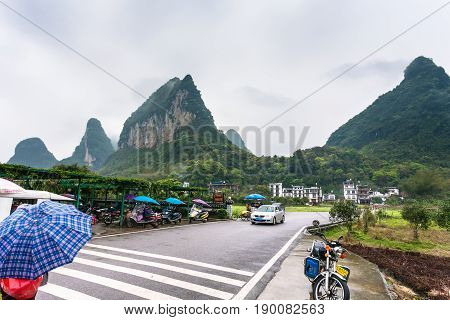 Car And Scooter Parking Lots Near Gate To Village
