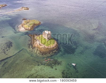 Aerial canoes gathering around the historic castle Stalker in Argyll, Scotland