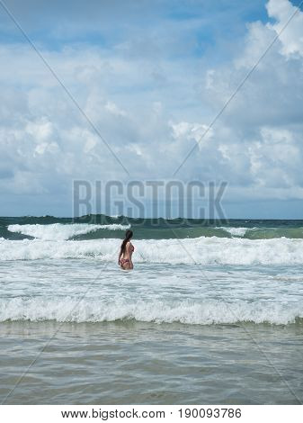 Girl on the beach. Waves of the Indian Ocean
