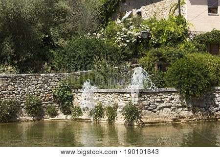 BAGNO VIGNONI, ITALY - JUNE 3 2017: Riflessi sculpture by Daniela Capaccioli in the medieal town of Bagno Vignoni in Tuscany Italy transparent metal wires sculptures