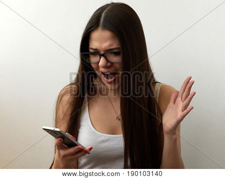 Young beautiful girl reading a message containing bad terrible news. Shock. White background.