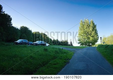 Kundratice Czech republic - May 19 2017: tourist cars parked on a gravel park near lookout tower named Varhost at evening