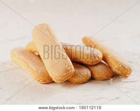 Close up view of ladyfinger biscuit cookie on white concrete background. Italian cookie savoiardi.