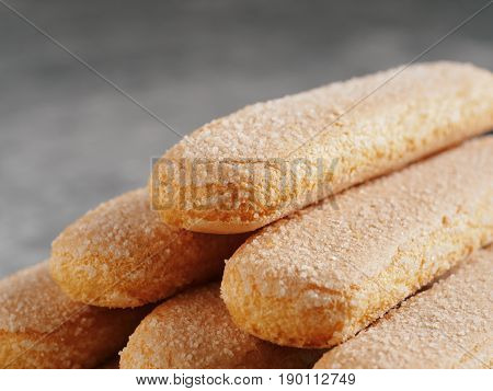 Close up view of ladyfinger biscuit cookie on gray concrete background. Italian cookie savoiardi. Copy space.