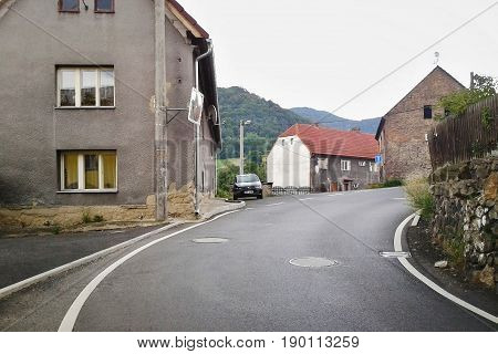 Sebuzin Czech republic - August 04 2012: archive photo with detail of village Sebuzin with asphalt path old houses and parked car Fiat Punto II in sommer rainy day