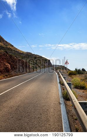Warning sign in a red triangle on a mountain road