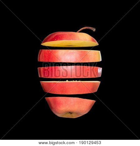 Flying apple. Sliced red apple isolated on black background. Levity fruit floating in the air