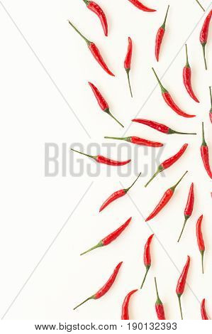 red hot chili peppers, popular spices concept - beautiful collage of uniformly distributed red hot chili pepper on white background, top view, flat lay, free space for your text, vertical