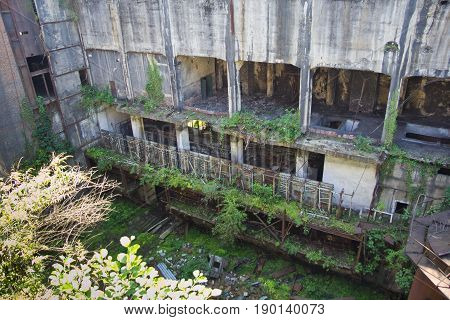 Abandoned overgrown ruins of destroyed by war Tkvarcheli (Tquarhcal) power plant, Abkhazia, Georgia