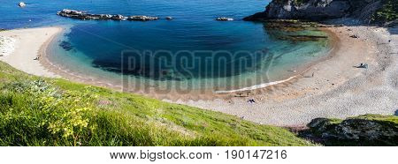 people enjoying a hot summer day on a beautiful hidden beach on the Jurassic Coast of Dorset, UK - Britiish summer holiday destination