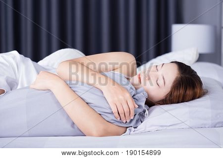 Woman Sleeping With Bolster Pillow On Bed In Bedroom