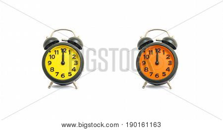 Closeup yellow alarm clock and orange alarm clock for decorate in 12 o'clock isolated on white background