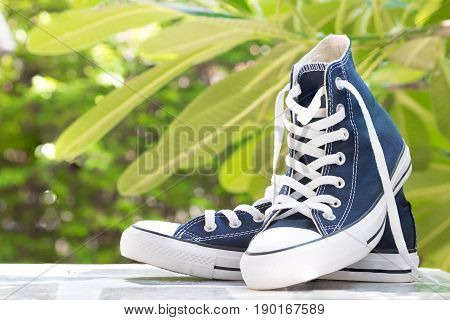 Pair of new blue sneakers on table top perspective and naturel background