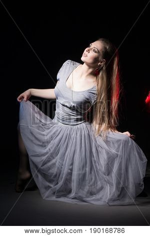 Actress In A Grey Dress On A Dark Stage