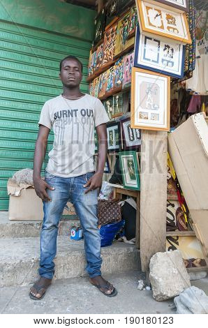 Young African male street vendor selling art pieces in the market. Abidjan, Ivory Coast, Circa May 2013.