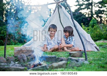 Two Sweet Children, Boy Brothers, Camping Outside Summertime On Sunset