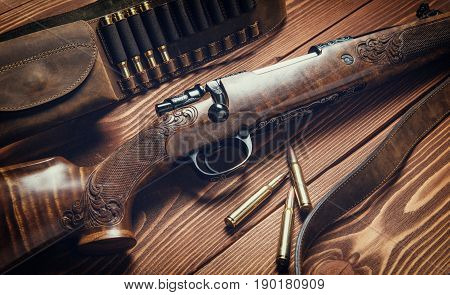 Hunting equipment on old wooden background and bullets.