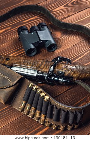 Hunting equipment on old wooden background and bullets.