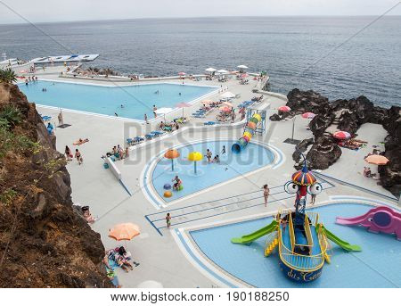FUNCHAL PORTUGAL - SEPTEMBER 3 2016: Swimming pool with tourists at Lido hotels zone in Funchal Madeira island Portugal