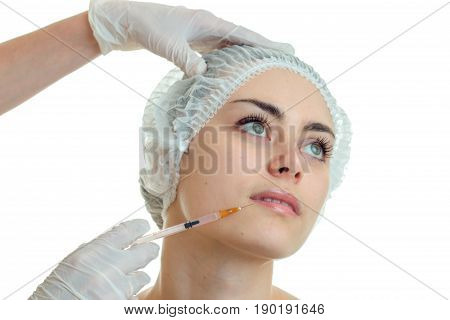 close-up portrait of a young cute girls hair in the CAP which holds facial procedures esthetician isolated on white