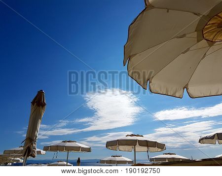 Umbrellas on the summer sandy beach in the sun