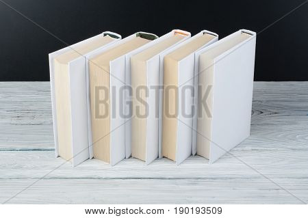 Open black and Whitel books on wooden table, black board background. Back to school. Education business concept