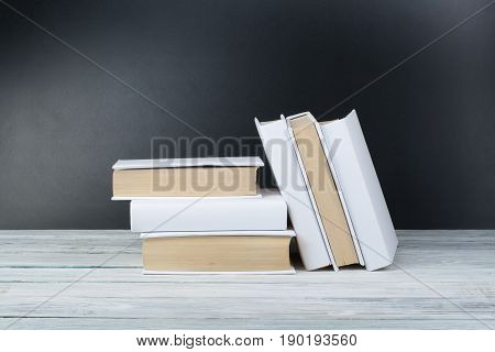 Open black and Whitel books on wooden table, black board background. Back to school. Education business concept