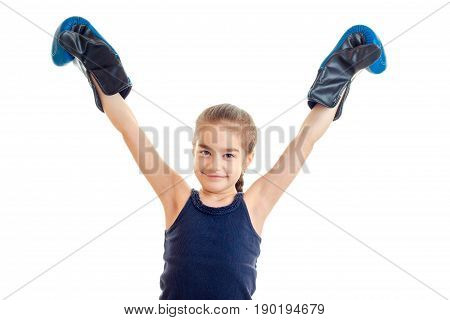 cheerful little girl in bloe boxing gloves with hands up smiling isolated on white background