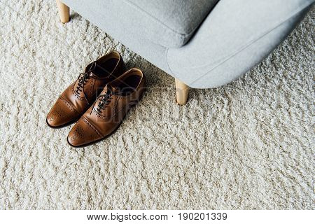 Close Up Of Leather Oxford Shoes On Carpet Near Textile Armchair
