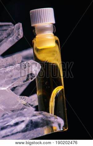 Detail of cannabis oil container and quartz crystal isolated on black - medical marijuana concept