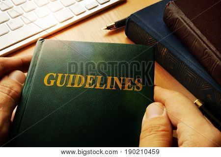 Hands holding A Guidelines in an office.