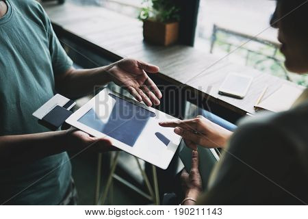 Hands of woman entering information in application on digital tablet to pay for the order