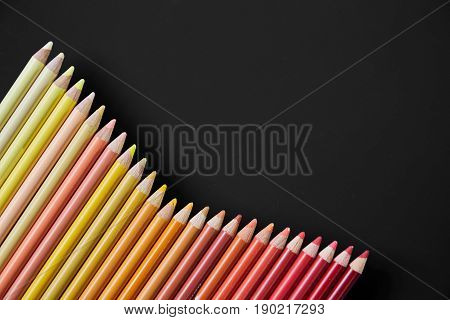 Colour pencils isolated on black background close up