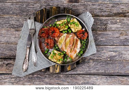 Baked fish with lemon and vegetable garnish. Selective focus.