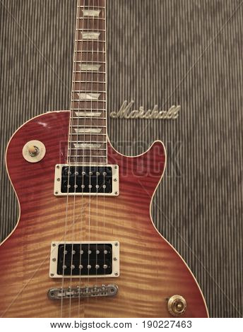 The classic rock combination of a Gibson Les Paul electric guitar leaning against a Marshall amplifier in a music retail shop 