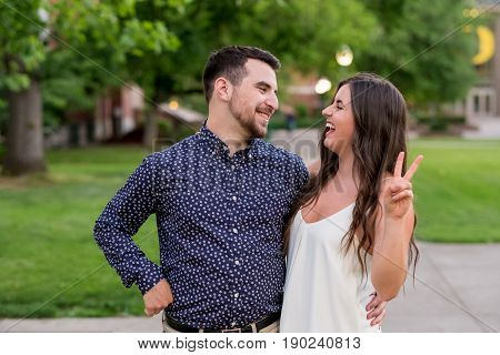 Two college students being funny for the camera during their graduation photos on campus at a university.